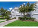 Two-story townhome with gray exterior, two-car garage, and landscaped yard at 15223 Windmill Harbor Ct, Orlando, FL 32828