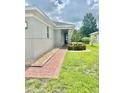 Side view of the house with a brick walkway and landscaping at 3201 Songbird Cir, Harmony, FL 34773