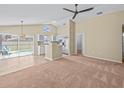 Open-concept living space with high ceilings, fan, and sliding doors to the pool area at 2977 Kokomo Loop, Haines City, FL 33844