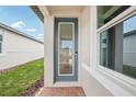 Close-up of a modern glass front door entrance with brick pavers, providing a bright, welcoming view inside at 507 Kennedy Dr, Lake Alfred, FL 33850