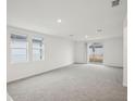 Spacious living room featuring neutral carpet, natural light, and a sliding glass door to the backyard at 507 Kennedy Dr, Lake Alfred, FL 33850