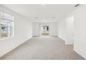 Bright and airy living room with neutral carpet, large windows, and sliding glass doors to the backyard at 507 Kennedy Dr, Lake Alfred, FL 33850