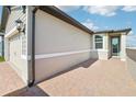 A home exterior is seen with a brick paver driveway leading up to an attached garage and covered entry at 510 Kennedy Dr, Lake Alfred, FL 33850