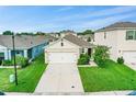 Tan house with white garage door, driveway and lawn, aerial view at 2321 Tay Wes Dr, Saint Cloud, FL 34771