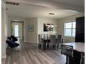 Bright dining room featuring modern light fixture and gray wood flooring at 9238 Kensington Row Ct, Orlando, FL 32827