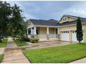 Charming home with two-car garage, covered porch, stone accents, and manicured lawn at 9238 Kensington Row Ct, Orlando, FL 32827