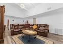 Spacious living room with vaulted ceiling, comfy leather seating, and stylish decor on wood floors at 1521 Oxford Rd, Maitland, FL 32751