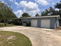 Exterior view of home featuring a three-car garage, manicured landscaping, and a concrete driveway at 1951 S Crystal Lake Dr, Orlando, FL 32806