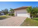 Home exterior showcasing a white garage door and brick paver driveway at 310 Villa Sorrento Cir, Haines City, FL 33844
