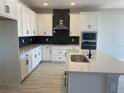 Modern kitchen featuring stainless appliances, ample cabinetry, a functional island, and stylish black backsplash at 16875 Muskgrass Dr, Winter Garden, FL 34787