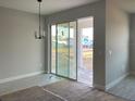 Bright living room featuring sliding glass doors and modern chandelier at 16875 Muskgrass Dr, Winter Garden, FL 34787