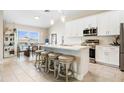 Bright, open kitchen with large island, stainless appliances, and adjacent dining area at 1302 Belmar Ter, Deltona, FL 32725