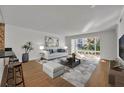 Bright living room featuring a white sofa, modern coffee table, and large windows with view to the outside landscape at 700 Melrose Ave J 1 Ave # J1, Winter Park, FL 32789