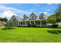 Two-story house with a wrap-around porch and landscaped lawn at 5155 Lake Deeson Woods Ct, Lakeland, FL 33805