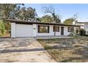 White house with dark brown accents, a garage, and a long driveway at 4410 Rossmore Dr, Orlando, FL 32810