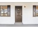 Dark brown front door with decorative panels and sidelight windows at 4410 Rossmore Dr, Orlando, FL 32810