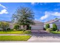 Inviting single-Gathering home featuring brick driveway, well-maintained lawn, and mature landscaping under a blue sky at 992 Jetway St, Orange City, FL 32763