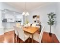 Elegant dining room featuring hardwood floors, stylish chandelier, and an open view to the kitchen at 16950 Se 80Th Bellavista Cir, The Villages, FL 32162