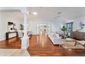 Bright living room featuring hardwood floors, a ceiling fan, and an open layout with access to other rooms at 16950 Se 80Th Bellavista Cir, The Villages, FL 32162