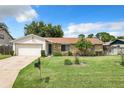 House exterior showcasing a stone and wood facade, driveway, and well-maintained lawn at 104 E Berkshire Cir, Longwood, FL 32779