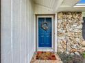 Inviting blue front door with a fall wreath and a welcome mat at 104 E Berkshire Cir, Longwood, FL 32779