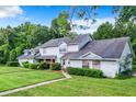 Traditional townhome exhibits a well-manicured lawn, classic siding, and mature trees at 1624 Rivers Edge Dr, Orlando, FL 32825
