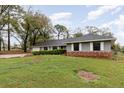 Attractive ranch-style home with well-maintained lawn, showcasing brick accents and mature trees at 6682 Sw 106Th Ln, Ocala, FL 34476