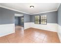 Spacious living room featuring decorative molding, neutral paint, and tile flooring at 6682 Sw 106Th Ln, Ocala, FL 34476