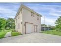 Rear exterior view showcasing a spacious yard and a two-car garage at 821 E Story Rd, Winter Garden, FL 34787