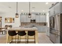 Modern kitchen with gray cabinets, granite countertops, pendant lighting, stainless steel refrigerator, and tile flooring at 5232 Villa Rosa Ave, Saint Cloud, FL 34771