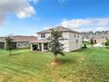 Spacious backyard with covered patio and grassy area at 8060 Cherrystone St, Leesburg, FL 34748
