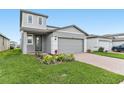 Attractive two-story home with manicured lawn and garden beds, a two-car garage and a covered entry at 1386 Current Pl, Haines City, FL 33844