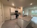 Modern kitchen with white cabinets, granite countertops, and stainless steel appliances at 2008 Red Rock Rd, New Smyrna Beach, FL 32168