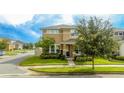 Tan two-story house with a landscaped yard and a blue door at 16467 Olive Hill Dr, Winter Garden, FL 34787