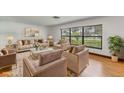 Bright living room with large windows, stylish furniture and decor, and hardwood floors at 20319 Macon Pkwy, Orlando, FL 32833