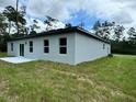 Rear view of the house showcasing a sliding glass door and a small patio at 3325 Sw 165Th Loop, Ocala, FL 34473