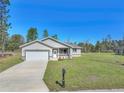 Charming single-story home features a well-manicured lawn and an attached two-car garage at 15062 Sw 63Rd Court Rd, Ocala, FL 34473