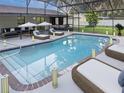 Relaxing screened-in pool area with lounge chairs, umbrellas, and decorative lighting at 4814 Lake Shore Dr, St Cloud, FL 34772