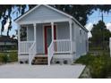 Newly built light gray house with white porch and red front door at 0 2Nd St, Oviedo, FL 32765