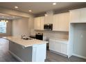 Modern kitchen with white cabinets, island, and stainless steel appliances at 9279 Gran Teatro Dr, Winter Garden, FL 34787