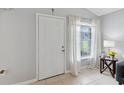 Bright and airy entryway with a neutral color palette, a large window and tiled floors at 805 Nelson Dr, Kissimmee, FL 34758