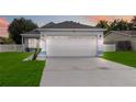 House exterior view at dusk showing a white two-car garage at 805 Nelson Dr, Kissimmee, FL 34758