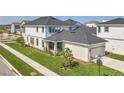 Aerial view of a two-story home with an attached garage and well-maintained lawn in a suburban neighborhood at 9982 Fiddley Aly, Orlando, FL 32827
