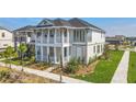 Charming two-story home featuring a covered porch, balcony, and beautifully landscaped front yard at 9982 Fiddley Aly, Orlando, FL 32827