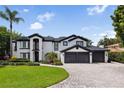 Elegant two-story home with a three-car garage, manicured lawn, and lush landscaping at 904 Main St, Windermere, FL 34786