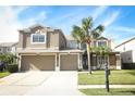 Two-story home featuring three-car garage, tan exterior paint, manicured lawn and a mailbox at 14126 Fox Glove St, Winter Garden, FL 34787