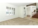 Bright and airy living room with plush carpet, plantation shutters, and entry with staircase at 14126 Fox Glove St, Winter Garden, FL 34787
