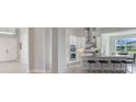 Bright, open-concept kitchen featuring white cabinetry, stainless steel appliances, and a sleek island with bar seating at 16033 Barkly Ridge Ct, Winter Garden, FL 34787