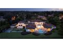 Luxurious estate with pool, hot tub, sport court, dock, and manicured lawns illuminated at twilight at 1965 Lake Markham Preserve Trl, Sanford, FL 32771