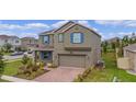 Two-story house with blue shutters and a brick driveway at 2003 American Beech Pkwy, Ocoee, FL 34761